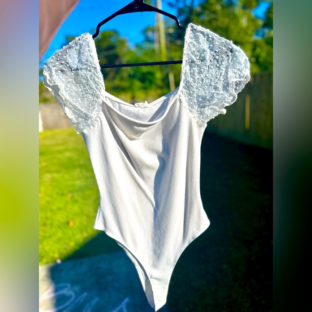 White bodysuit with puffy sheer sleeves and detailing. Size small